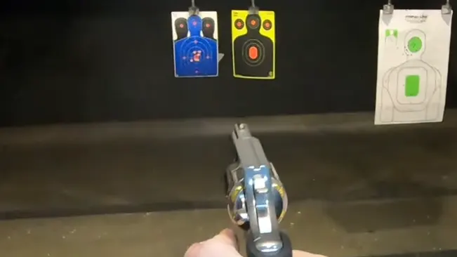Point of view of a King Cobra Carry revolver aimed at shooting range targets, held in a hand.