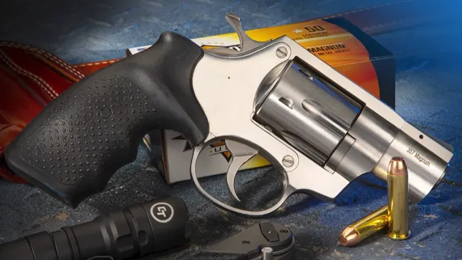 Rock Island Armory AL3.1 revolver with ammunition and accessories on a blue surface.