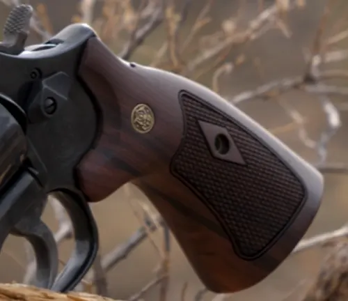 Close-up of the wooden grip and emblem on a Smith & Wesson Model 586 revolver.